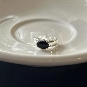 Detail of a 925 silver ring with an oval black onyx stone in a minimalist open design