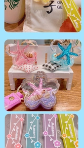 Macro detail of star-shaped liquid acrylic keychain with starfish, shell and glitter