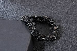 Macro shot of matte black 316L stainless steel curb chain with carved skull detailing