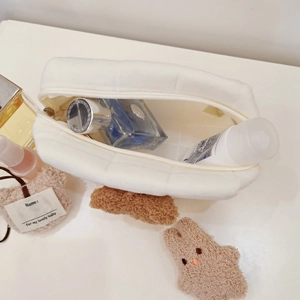 Detailed top view showing open quilted plush bag with cosmetics inside for storage