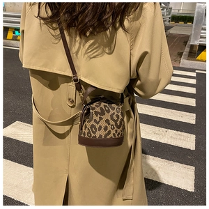 Street style shot of a vintage leopard print crossbody bag worn on a model's back