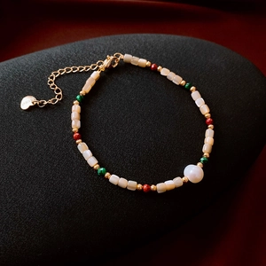 Macro shot of 18k gold plated bracelet with freshwater pearls and square shell beads