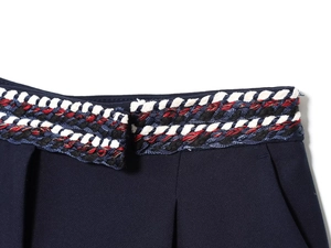 Détail macro de la bordure tissée tricolore et du tissu texturé bleu marine de qualité