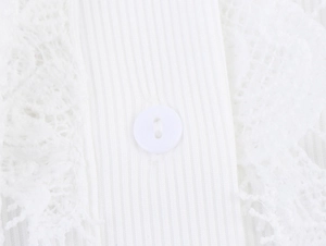 Close-up of white knitted bodysuit with lace trim and round button detail