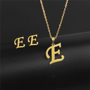 Detailed macro view of gold-plated stainless steel letter E necklace and earrings set