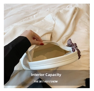 Detail showing the spacious interior of white crescent handbag with silk scarf handle