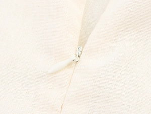 Detailed close-up of invisible zipper and woven cotton linen fabric on a resort set