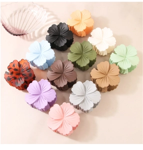 Flat lay of matte floral hair claws in twelve assorted colors for elegant hair styling