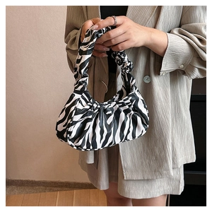Close-up of zebra print ruched cloud bag showing soft PU leather texture and pleated design