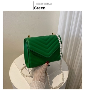 Detail of green V-quilted faux leather crossbody bag with elegant faux pearl chain strap