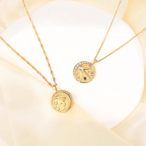 Colliers en or avec pendentifs soleil et lune et zircons colorés sur fond de soie