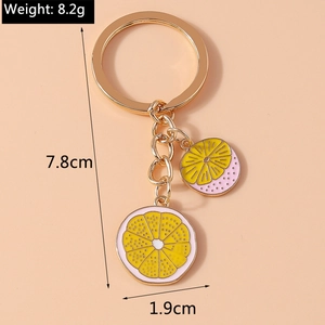Detailed view of lemon slice keychain dimensions and weight on peach background