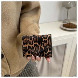 Dettaglio di un portafoglio triplo con stampa leopardata tenuto da una modella