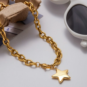 Close-up of golden stainless steel chain with a chunky star pendant and lobster clasp