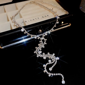 Detailed close-up of a silver rhinestone fringe necklace with brilliant star-like sparkles