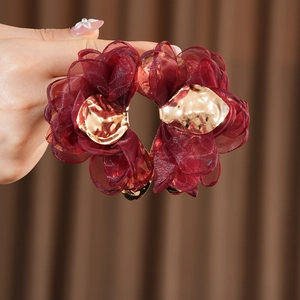 Close-up of dark red chiffon flower earring with a gold metallic center detail