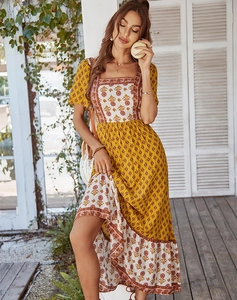 Detail of bohemian yellow floral midi dress with square neckline in resort setting