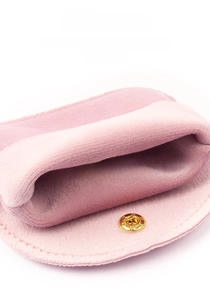 Macro detail of dusty rose velvet jewelry pouch featuring a gold snap button and fine stitching