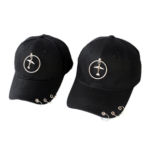 Black baseball cap with airplane pendant and silver metal ring piercings in streetwear style