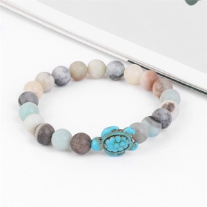 Detail of beach style beaded bracelet with natural stones and turquoise turtle charm