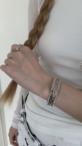 Close-up of silver mesh bracelet and ring set with sparkling zircon stone edges