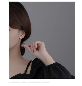 Close-up of elegant gold garland stud earrings with sparkling diamonds on a model