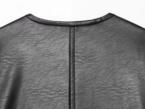 Detail of black pebbled leather neckline and back seam stitching with refined texture