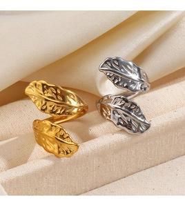 Macro detail of gold and silver feather rings showing intricate leaf vein textures