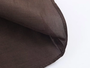 Détail macro du tissu tissé marron foncé avec coutures précises et texture raffinée