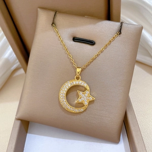 Close-up of gold moon and star pendant necklace with zircons in a jewelry box