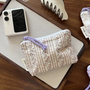 Detailed shot of a floral cotton mini pouch with zipper and simple wish label