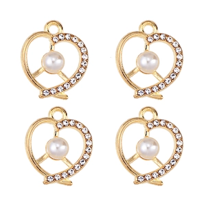 Detail of four golden heart charms with white pearls and sparkling zircons for DIY jewelry