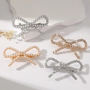 Elegant bow hair clips featuring pearls and rhinestones on decorative plaster base