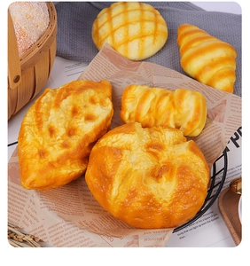 Set realista de croissants y pan artificiales en una cesta de metal negra