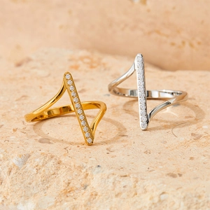 Minimalist geometric zircon ring in gold and silver finish on natural stone background