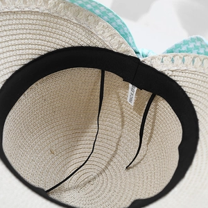 Women's beige woven straw hat with houndstooth ribbon and interior sweatband detail