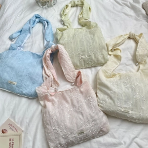 Vue à plat de quatre sacs en mousseline fleurie avec perles en couleurs pastel