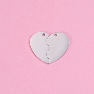 Pendentifs cœur en métal argenté pour colliers de couple sur fond rose uni