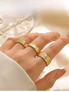 Detailed close-up of three vintage gold-tone stainless steel rings with bohemian engravings