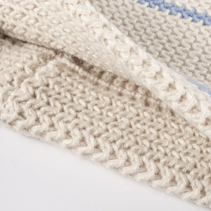 Close-up of a cozy off-white knit beanie with blue accent stripes for outdoor warmth