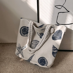 Canvas tote bag with blue ocean prints and thick rope handles for summer beach vacations