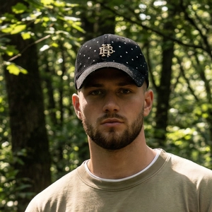 Vintage washed cotton baseball cap with white polka dots and gold embroidery in outdoor setting