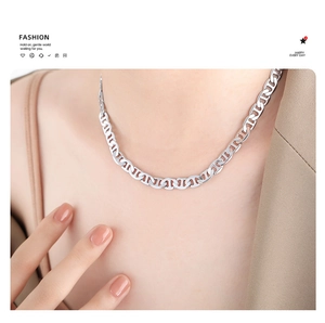 Close-up of a silver pig nose chain necklace on a female model for a minimalist fashion look