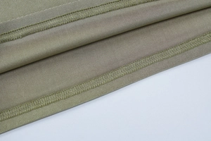 Detailed macro view of olive green fabric stitching and professional overlock seam finish