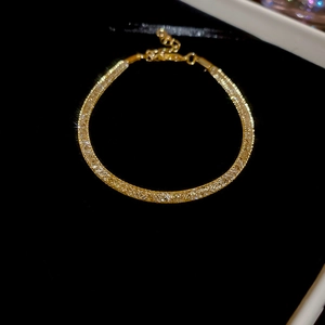 Bracelet en zircon doré avec fermoir mousqueton sur fond en velours noir élégant