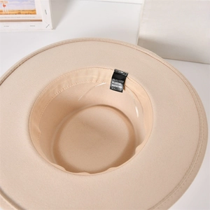 Detail view of the beige wool felt hat inner band and fabric care label for women