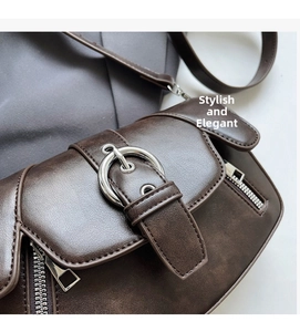 Detail of dark brown faux leather saddle bag featuring silver ring buckle and matte texture