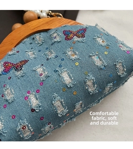 Detail of denim bag featuring butterfly sequins, pearl chain and vintage wooden handle