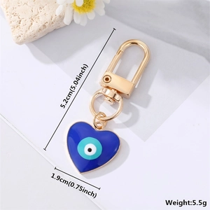 Detail view of heart-shaped evil eye keychain with gold clasp and size measurements