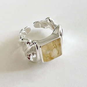 Close-up of S925 sterling silver ring with square amber stone and hammered metal texture